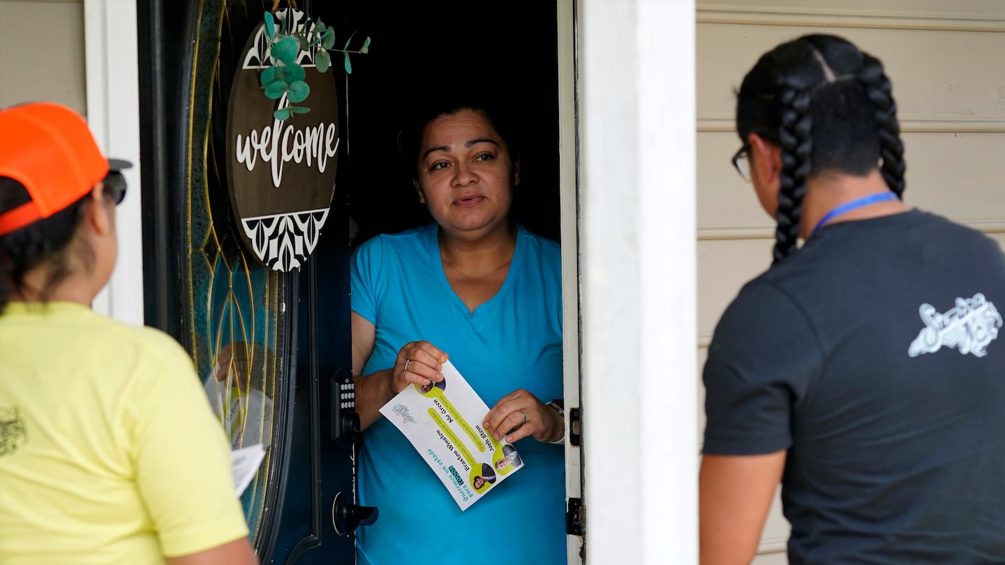 Salvador Fonseca, right, and Elena Jimenez, left, speak with Johanna Ortiz during a voter engagement event for the Latino community in Greensboro, N.C., on Sept. 21, 2024.