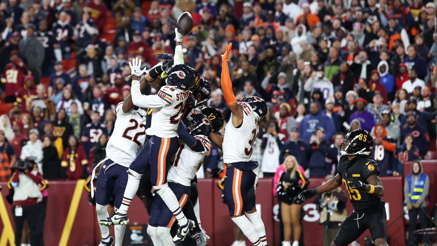 A last-second heave by Washington's Jayden Daniels got tipped into hands of receiver Noah Brown (right).