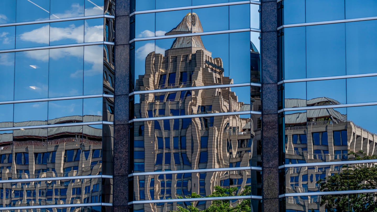 The Washington Post headquarters is reflected in an office building’s window. The paper's decision Friday to stop presidential endorsements has drawn harsh criticism. Earlier last week, the editorials editor of the Los Angeles Times resigned after that newspaper’s owner blocked the editorial board’s plans to endorse Democratic Vice President Kamala Harris for president.