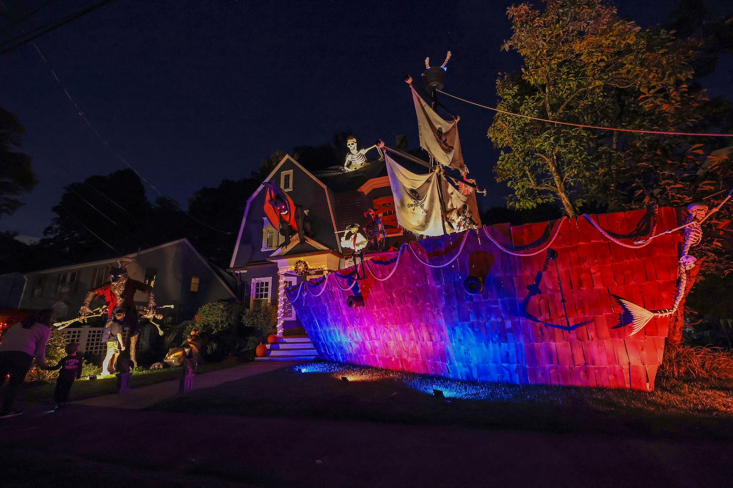 People examined the pirate ship-themed Halloween display built by Ted Lahey in Newton.