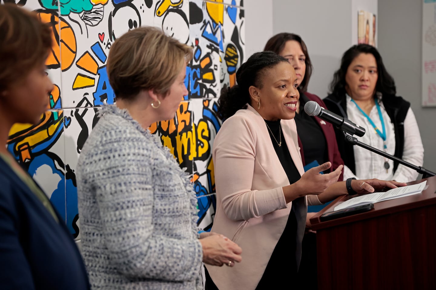 Parent and former Cambridge School Committee member Manikka Bowman speaks during a press conference where officials detail their opposition to Question 2, that would eliminate the MCAS as a graduation requirement.  She is flanked by from left, Attorney General Andrea Campbell, Governor Maura Healey, Lt. Gov. Kim Driscoll, and Friends of the Children Executive Director Yi-Chin Chen.