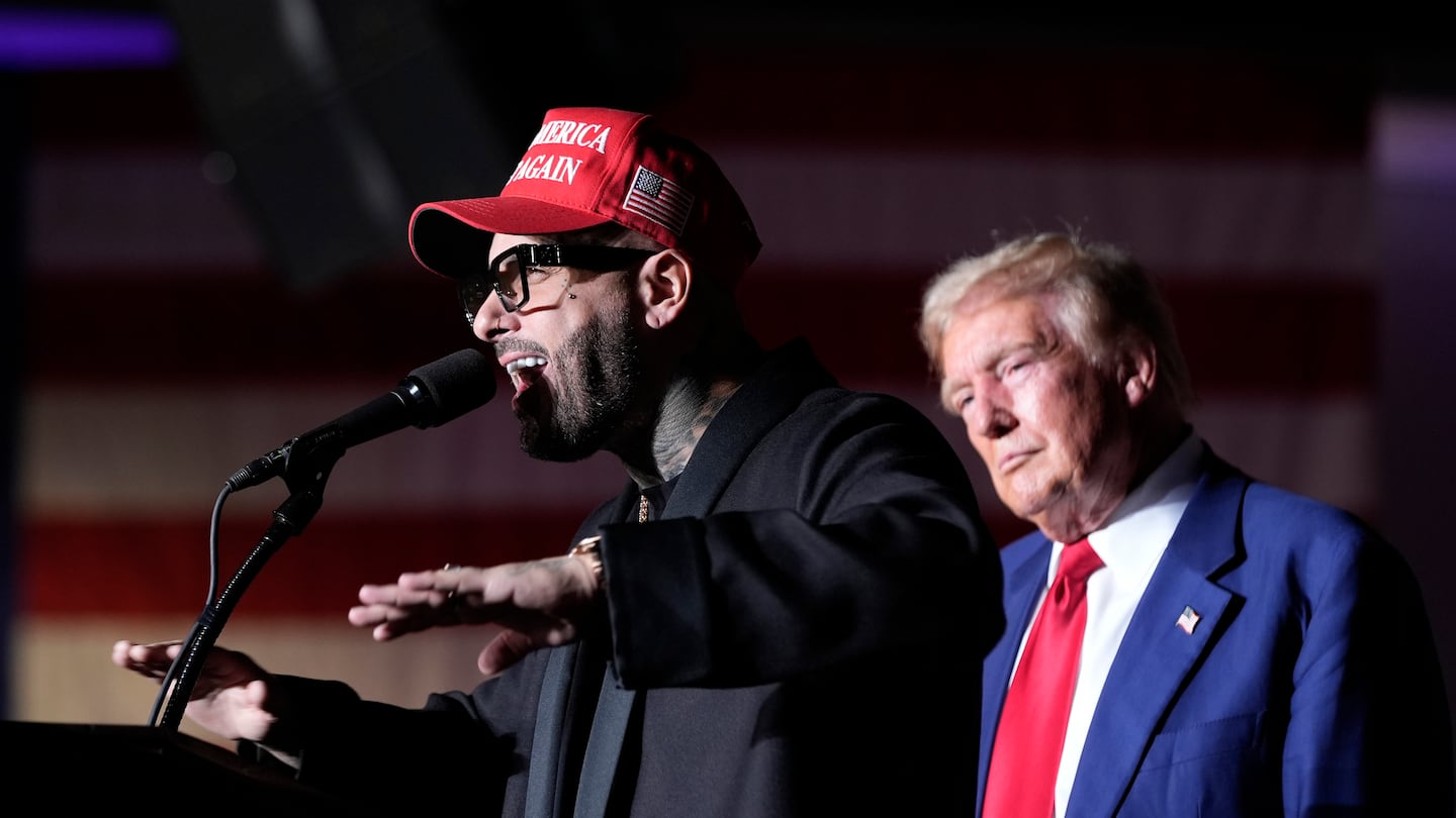 Nicky Jam speaks as Republican presidential nominee former president Donald Trump listens during a campaign event at the World Market Center, Sept. 13, 2024, in Las Vegas.