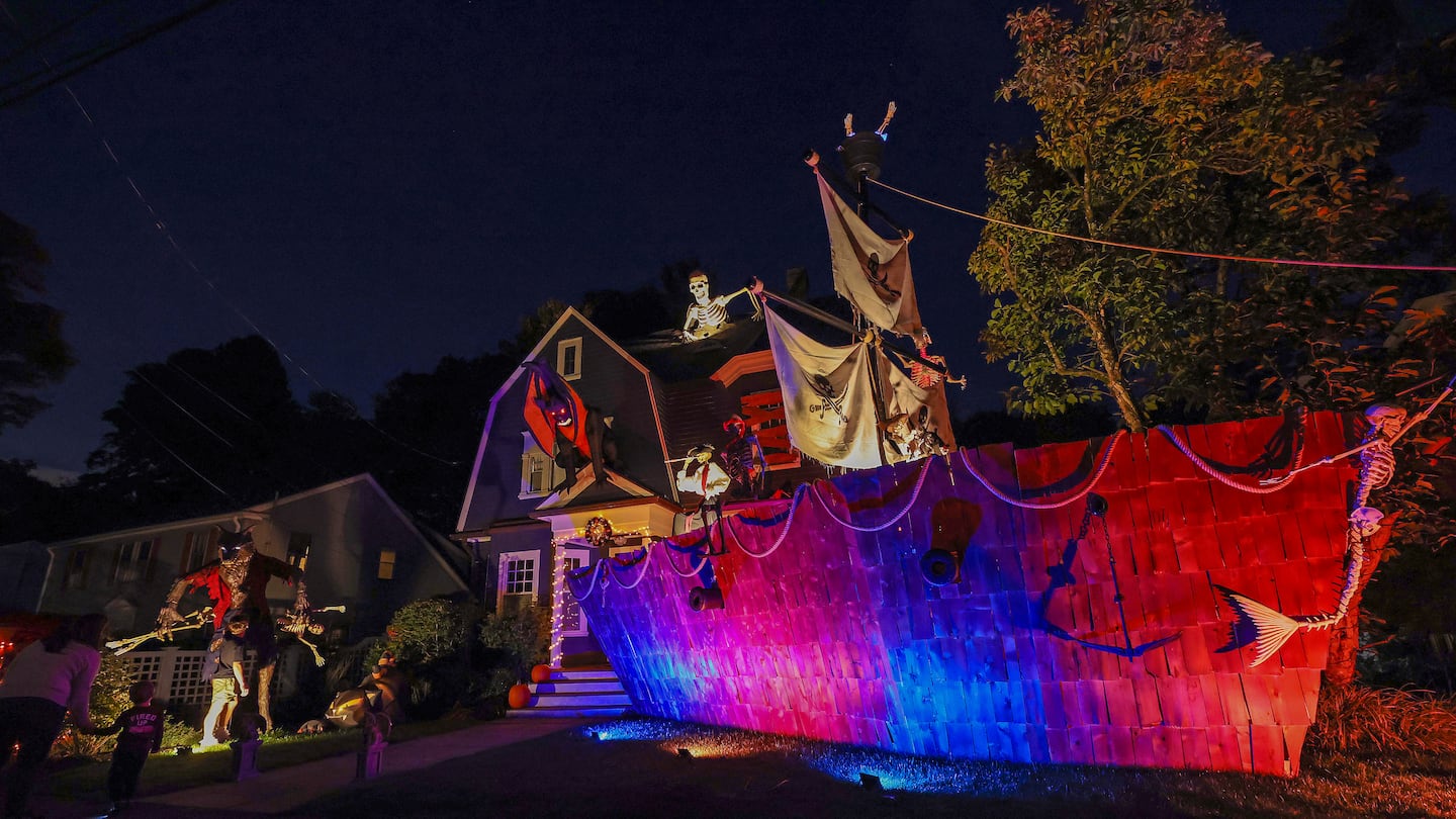 People examined the pirate ship-themed Halloween display built by Ted Lahey in Newton.