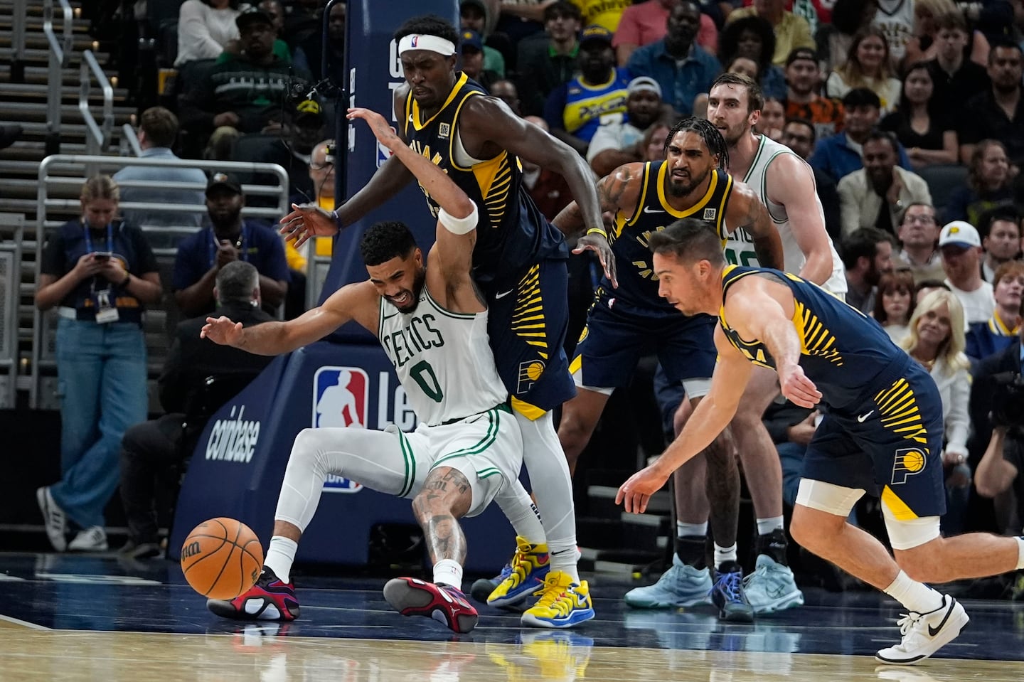 Celtics' Jayson Tatum (No. 0) looses control of the ball against Pacers forward Pascal Siakam (No. 43) and T.J. McConnell (No. 9) during the second half of Wednesday's 135-132 overtime loss in Indianapolis.