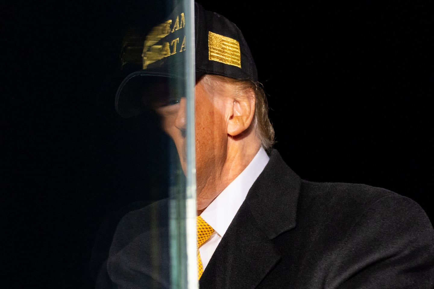 Donald Trump is reflected in bullet resistant glass before he speaks during a campaign rally in Traverse City, Mich, on Oct. 26.