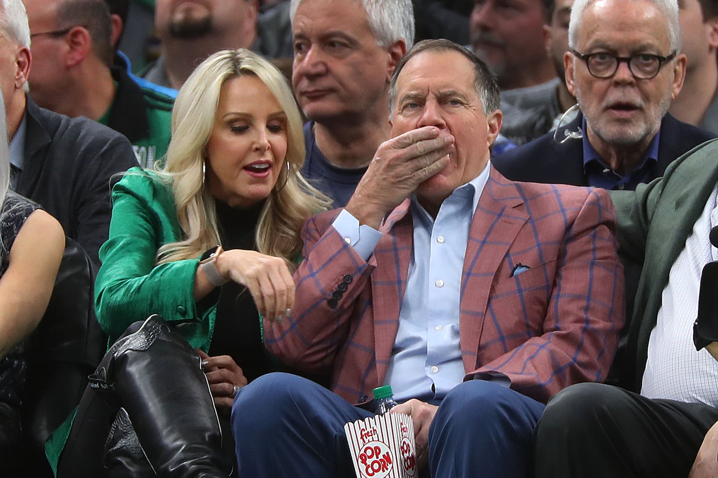 Patriots coach Bill Belichick enjoys popcorn courtside with Linda Holliday in 2019.