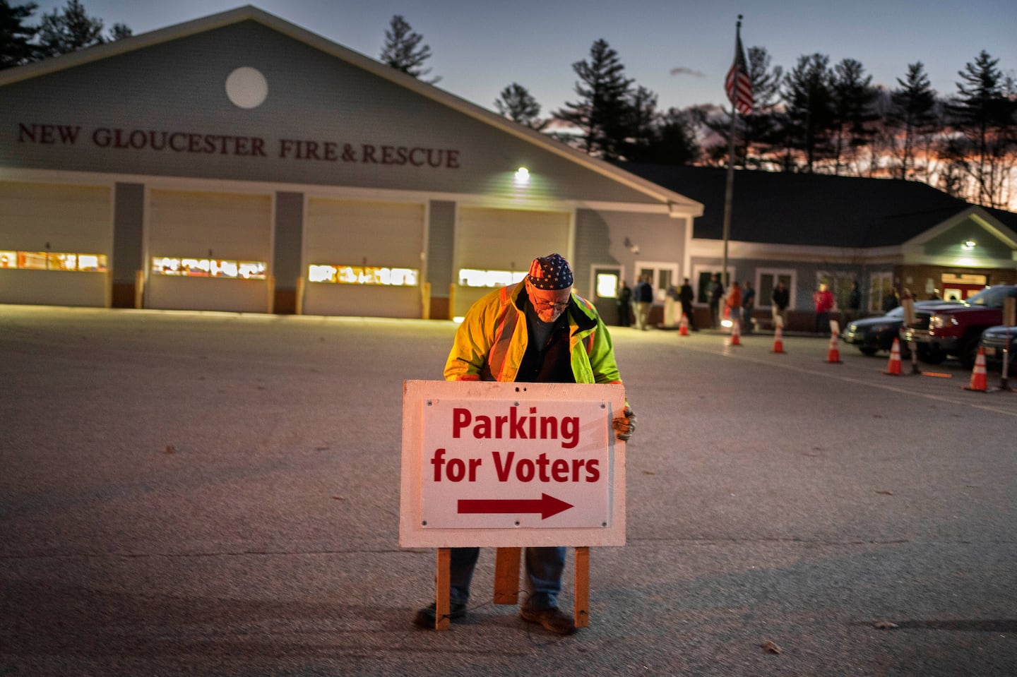 A man set up a sign shortly before the doors opened to voters at a polling location in the fire station in New Gloucester, Maine in November 2022.