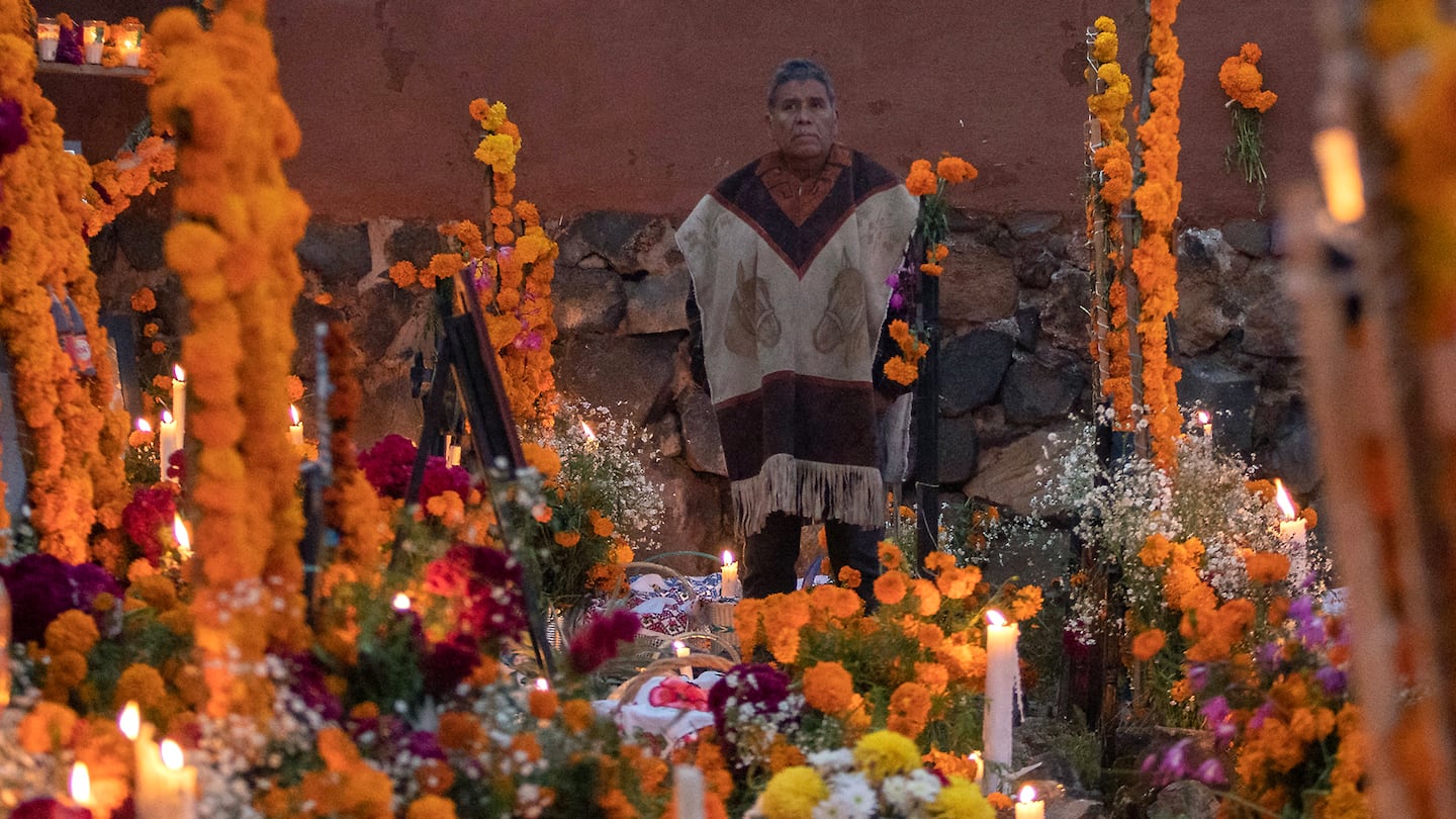 A man visited his deceased beloved one during the Day of the Dead commemoration, at the Arocutin churchyard in the Purepecha community on the shore of Lake Patzcuaro, Michoacan state, Mexico on Saturday.