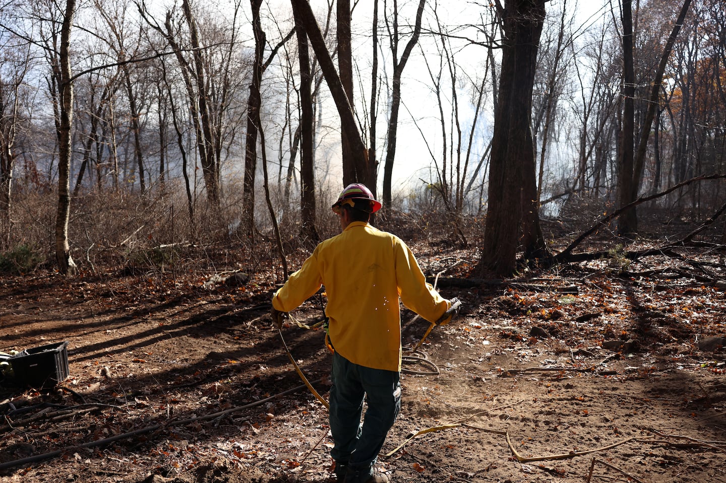 A firefighter worked to set up sprinklers around a brush fire in Middleton.