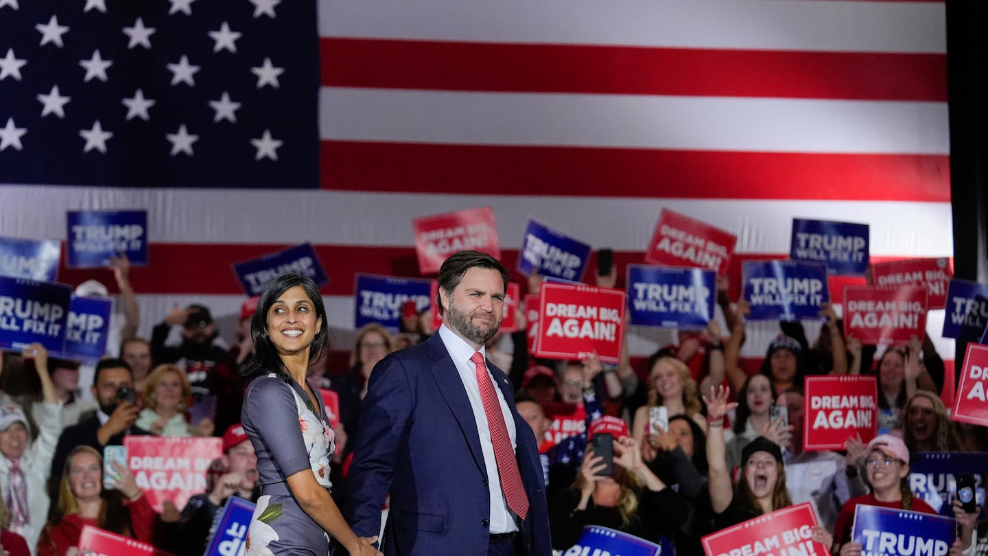 Republican vice presidential nominee Sen. JD Vance, R-Ohio, holds hands with his wife, Usha, during a campaign rally on Sunday, Nov. 3, 2024, in Derry, N.H. (AP Photo/Steve Senne)