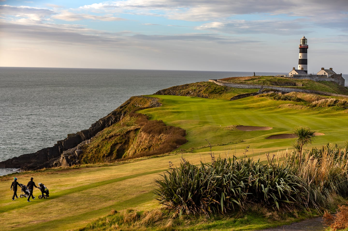 Mark Murphy and Eoin O’Connor walk toward Old Head Light on the 4th hole known as the Razor’s Edge at Old Head in Kinsale, Ireland.