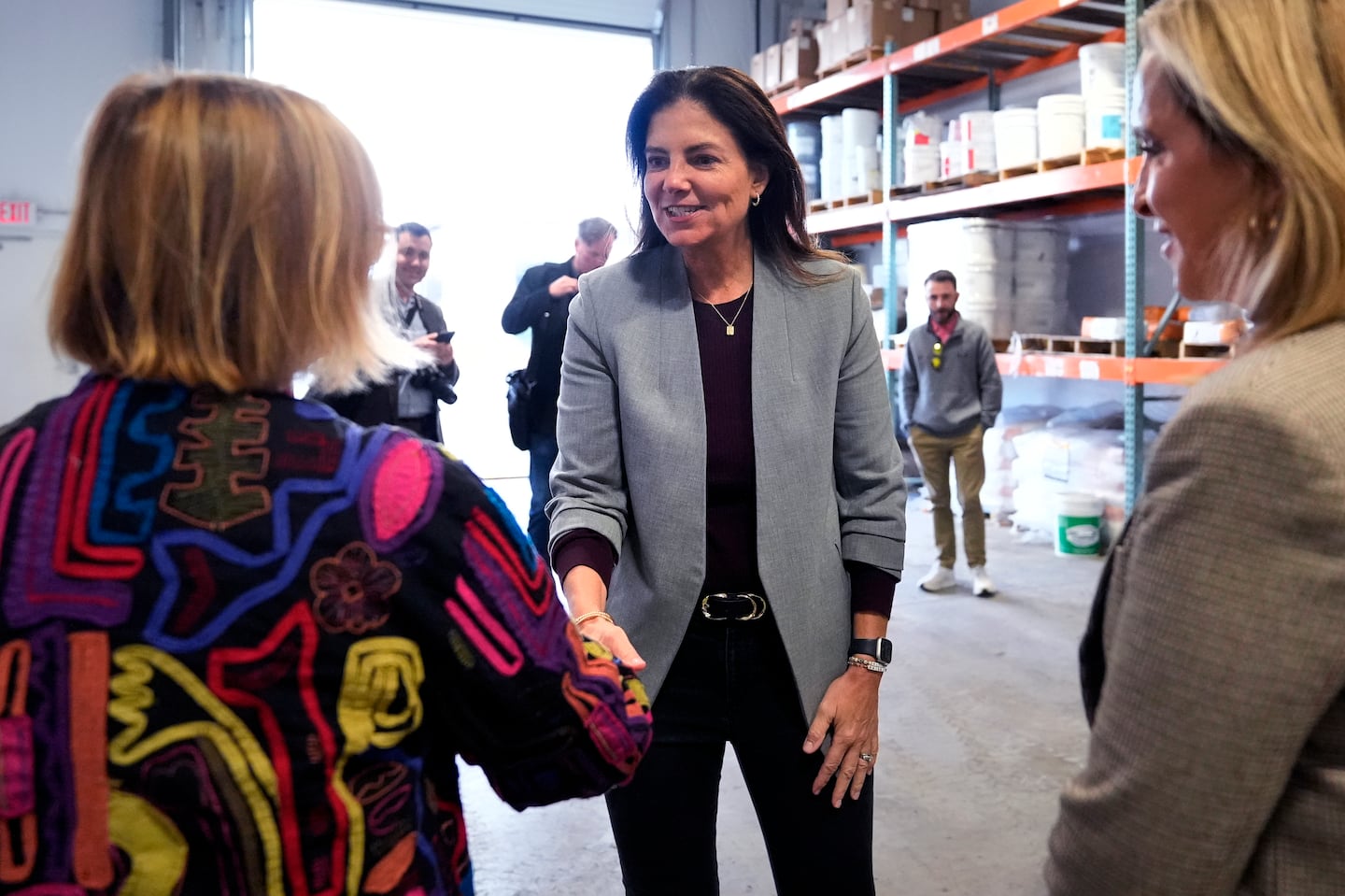 Republican gubernatorial candidate Kelly Ayotte, who faces Democrat Joyce Craig in the November 2024 election, shakes hands with administrators during a visit to a local concrete coating business on Oct. 16 in Manchester.