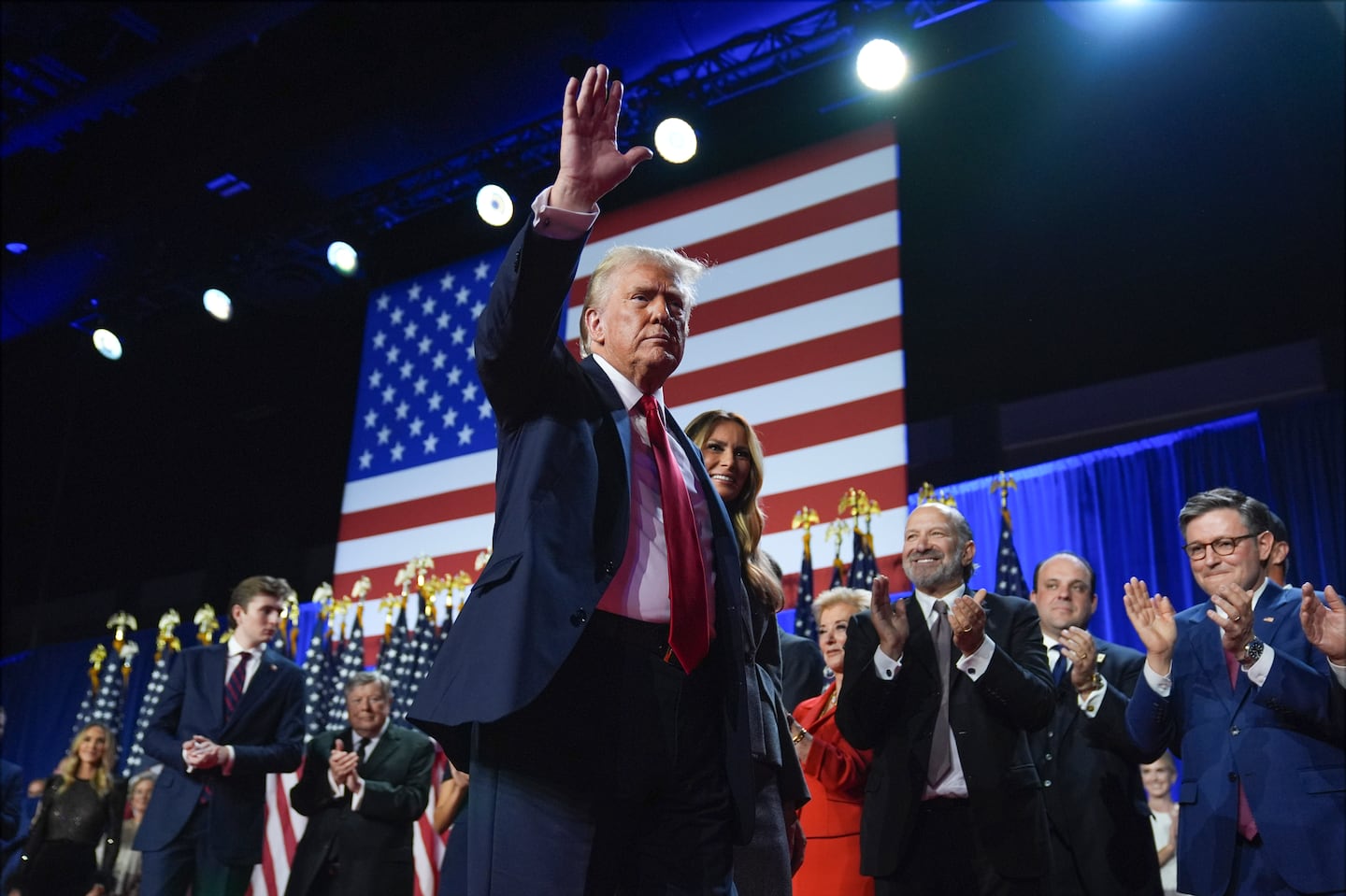 Republican presidential nominee former president Donald Trump waves as he walks with former first lady Melania Trump at an election night watch party at the Palm Beach Convention Center, Wednesday, Nov. 6, 2024, in West Palm Beach, Fla.