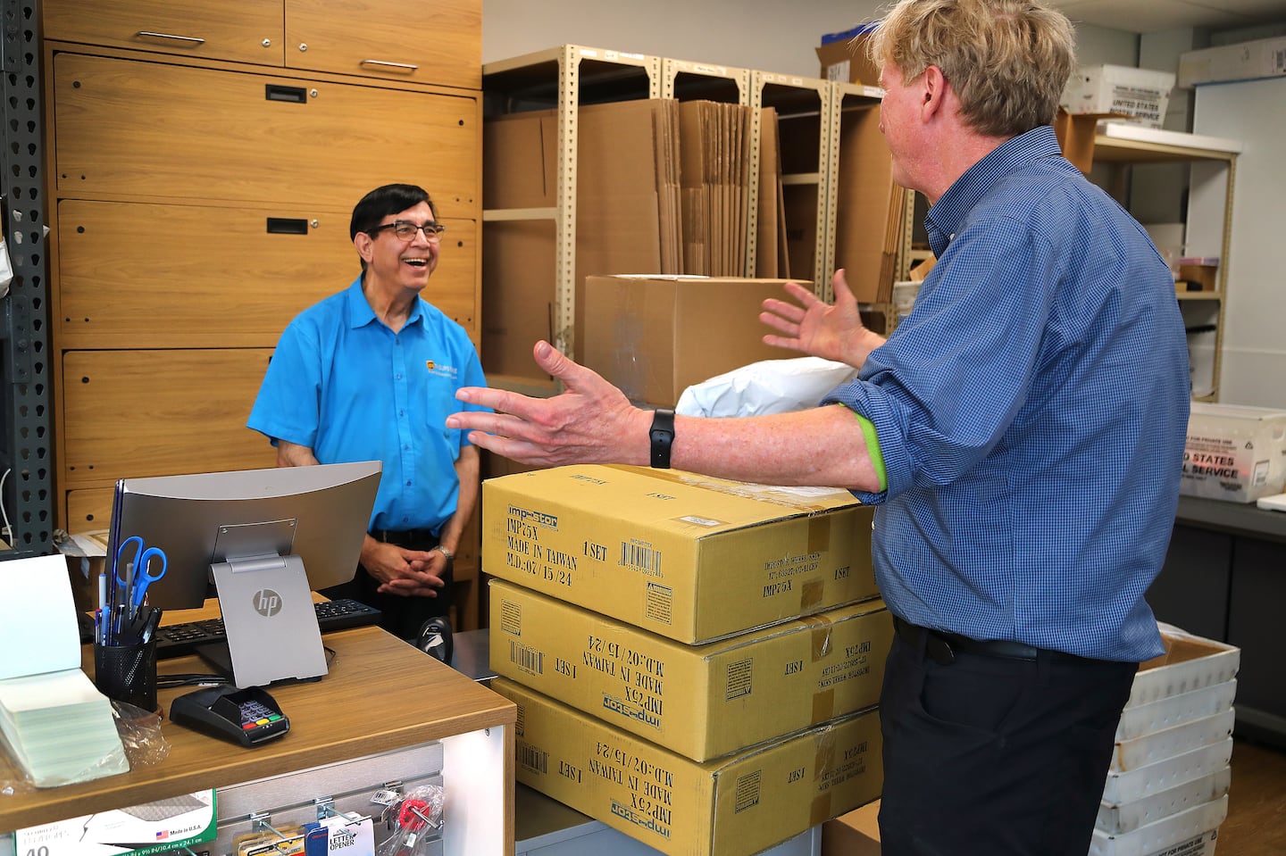 Sajid Bhatti, owner of a UPS store on Massachusetts Avenue in Cambridge, is retiring — to the chagrin of his customers like Brian Rafferty (right).