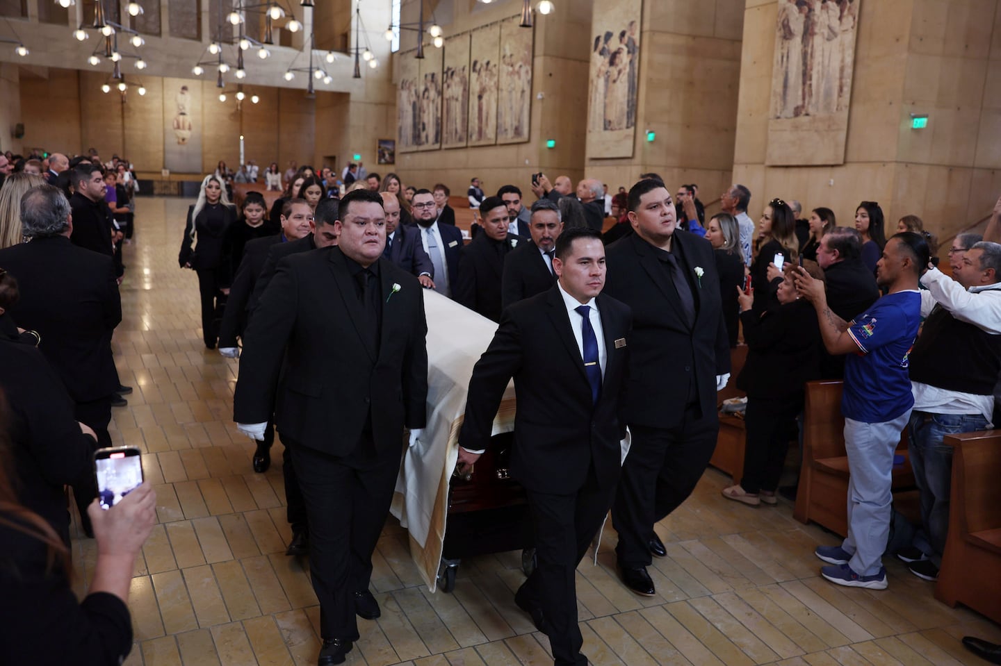 Fernando Valenzuela's sons, Fernando Valenzuela Jr. (left) and Ricardo Valenzuela (right) guide Dodgers pitcher Fernando Valenzuela's casket into the Cathedral of Our Lady of the Angels during a public funeral mass in Los Angeles.