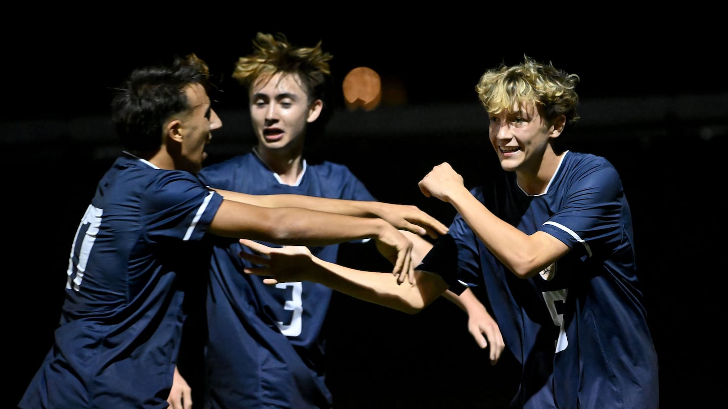 Lexington’s Milo Brandon (right) celebrates his first-half goal with teammates Marc Chedid (left) and Dillon Noonan (center) in Wednesday night's MIAA Division 1 boys’ soccer second-round matchup vs. Wellesley.