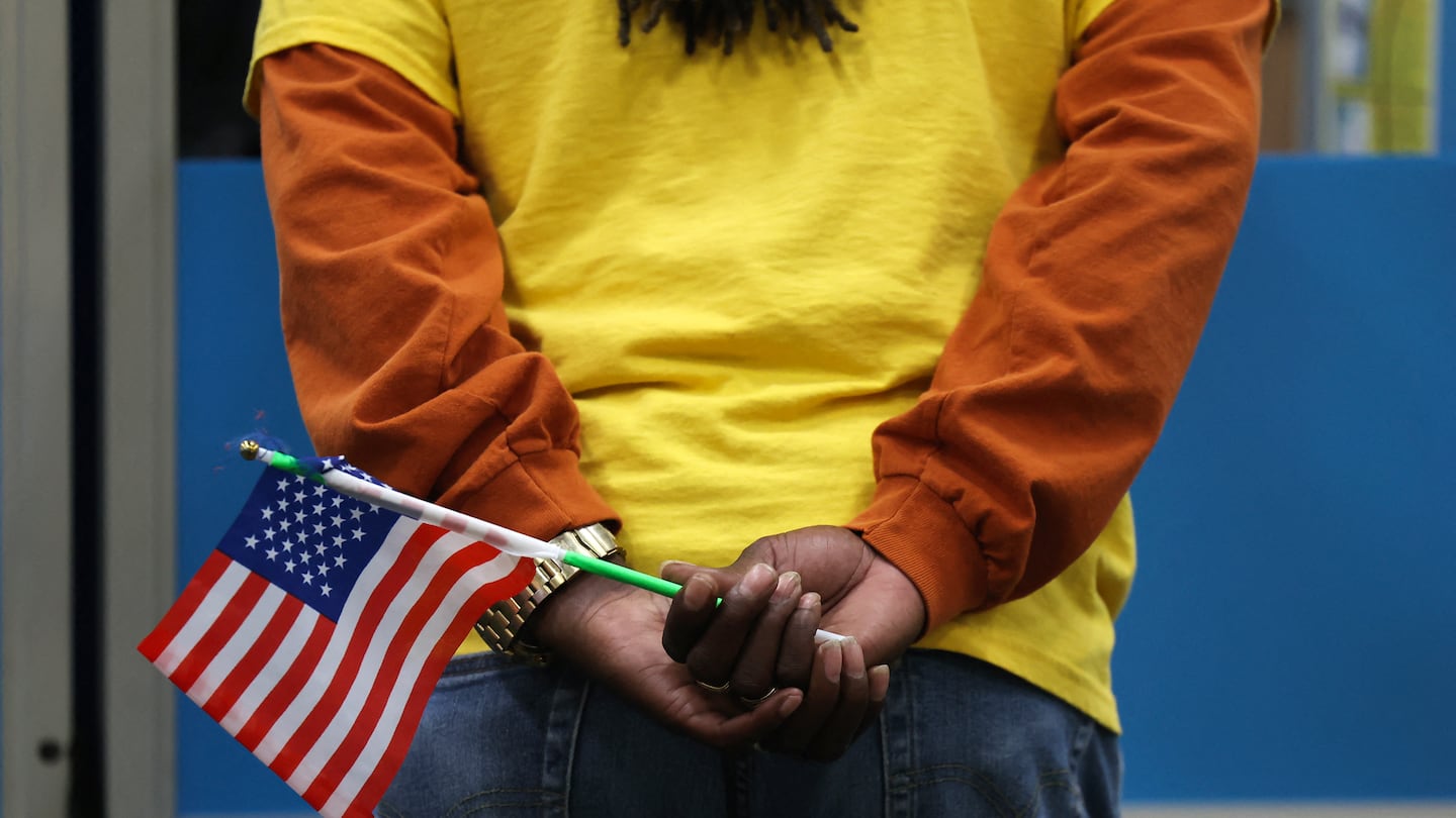 An election worker holds a flag while assisting voters at a polling station in Las Vegas, Nevada, on Election Day, Nov. 5, 2024.