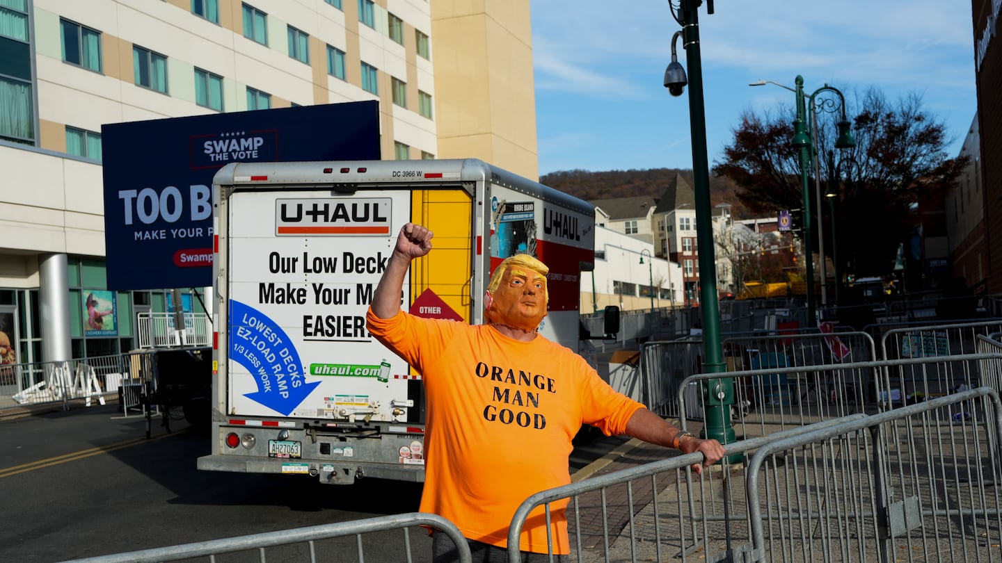 A Donald Trump supporter wearing a mask of the presidential candidate pumped his fist outside a Trump rally in Reading, Pa., on Nov. 4.