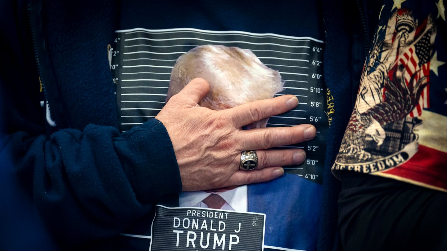 A supporter held his hand over his heart during the singing of the national anthem as Donald Trump took the stage at the Clinton Middle School in Clinton, Iowa, on Jan. 6,  2024.