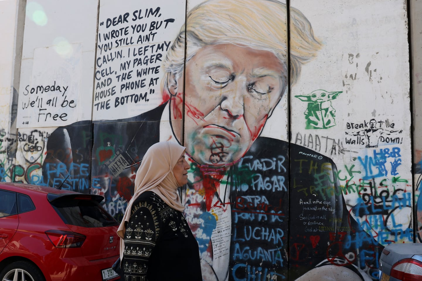 A Palestinian woman in the occupied West Bank walked past a mural depicting Donald Trump on Israel's separation wall on Tuesday.