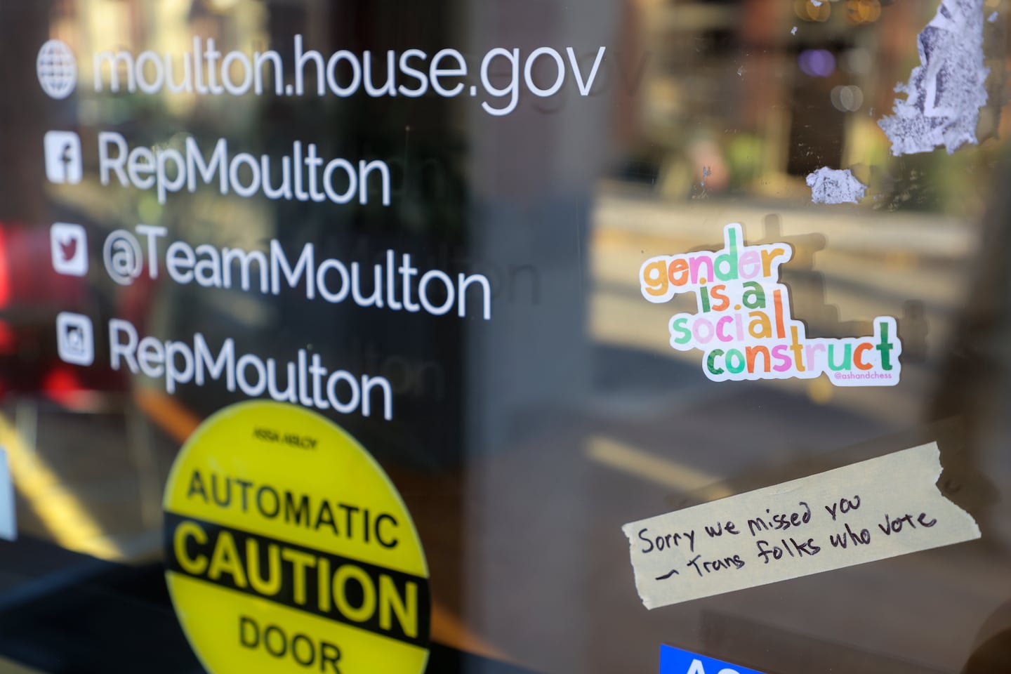 Protesters place taped stickers on the front door of Congressman Seth Moulton’s Salem office after he made comments about transgender athletes this in The New York Times this week.