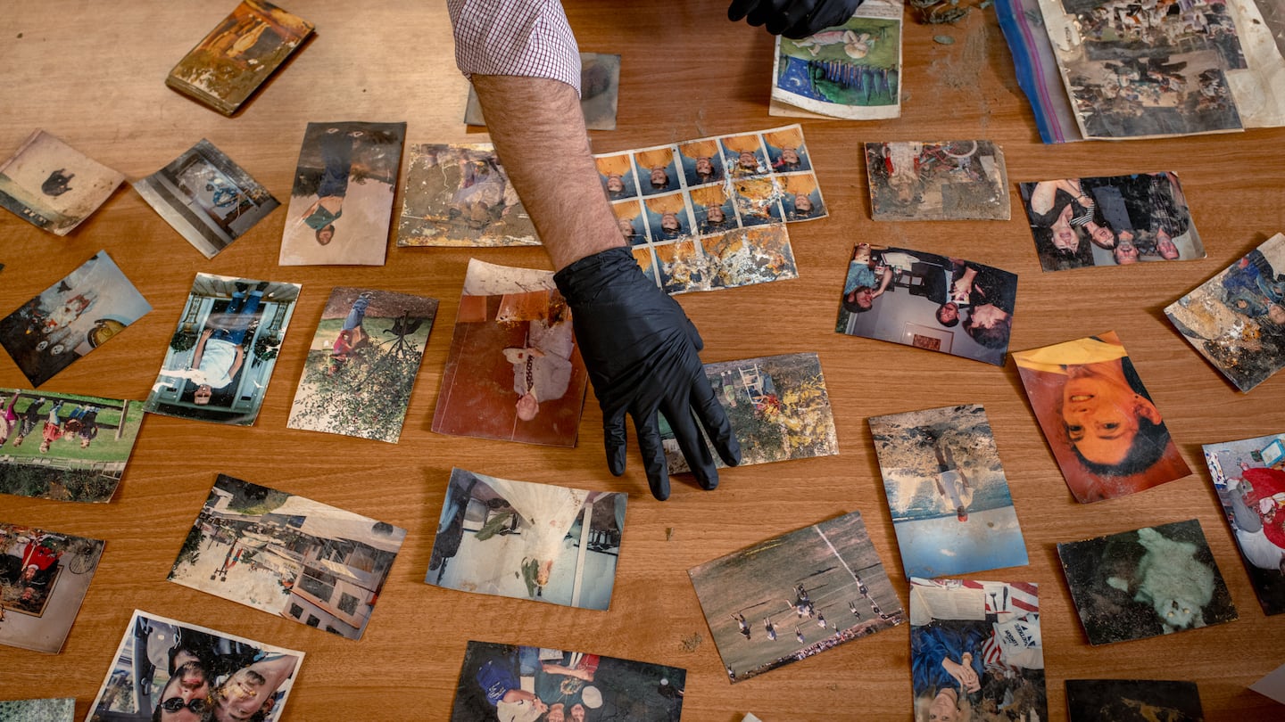 Detective Sam DeGrave sorted photos he recovered from debris piles after the widespread damage of hurricane Helene, at the police department in Asheville, N.C., last month.