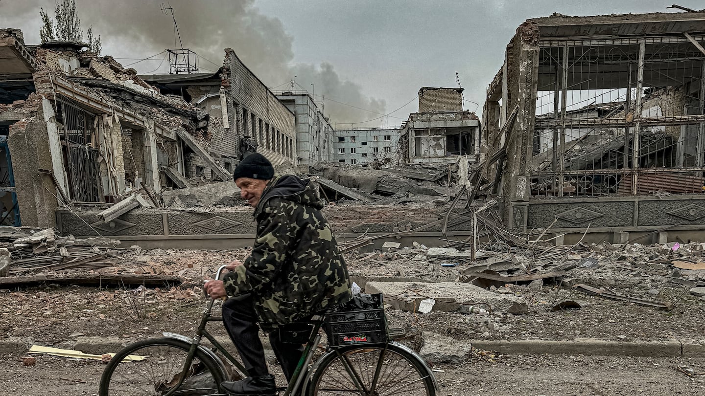 A man rides on a bike in front of the mail office which was destroyed by a Russian airstrike in Kurakhove, Donetsk region, Ukraine, on Nov. 7.