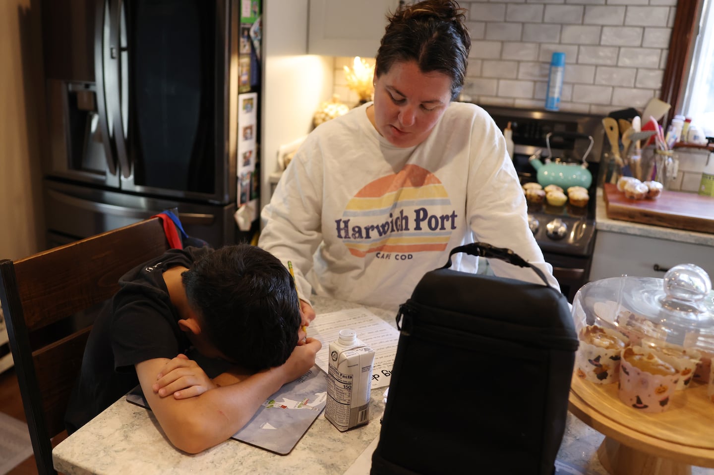 Jonathan Pagan put his head down as his mom, Jenni, wrote in the answers he gave her as they worked to complete a worksheet that asked him questions about his reading level and interests. Pagan is entering the fourth grade and only recently learned his letters despite being in a specialized district program.