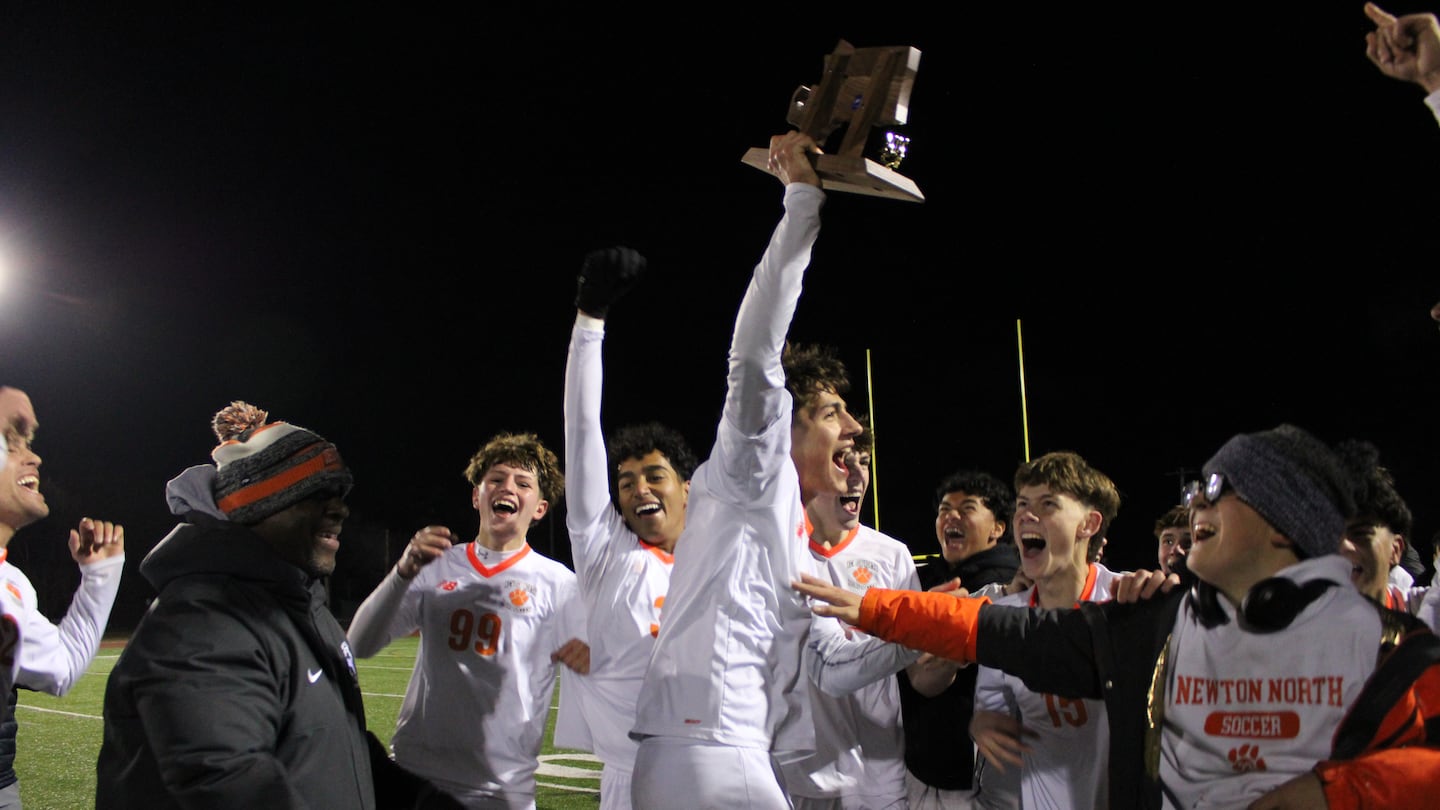 Senior Thiago Rubino hoists the trophy after Newton North's 1-0 quarterfinal victory over host Natick in the Division 1 quarterfinals.