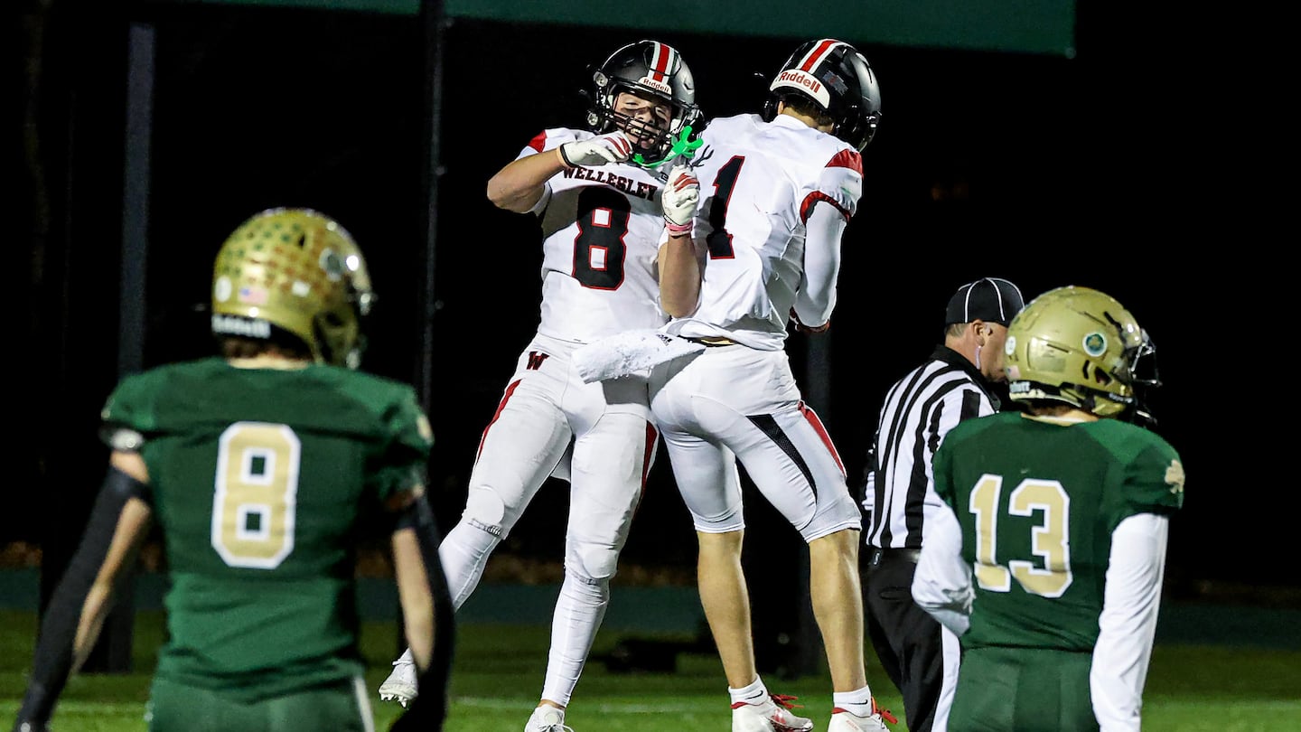 Wellesley's Will Zalosh (No. 8) and Matthew Leibman (No. 1) celebrate Zalosh's first-half touchdown catch for the fifth-seeded Raiders in Friday night's 14-7 Division 2 quarterfinal win over No. 4 Bishop Feehan in Attleboro.