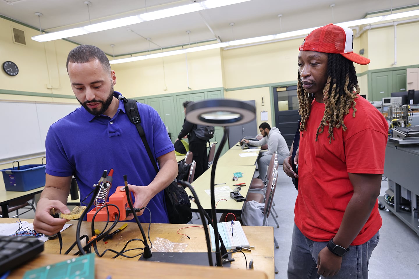 Osvaldo Medina (left) showed Alexander Harris a project in his Digital Principles lab class at the Benjamin Franklin Cummings Institute of Technology. Medina is studying engineering with a concentration in renewable energy technologies, while Harris is working toward a certificate in HVAC and refrigeration.