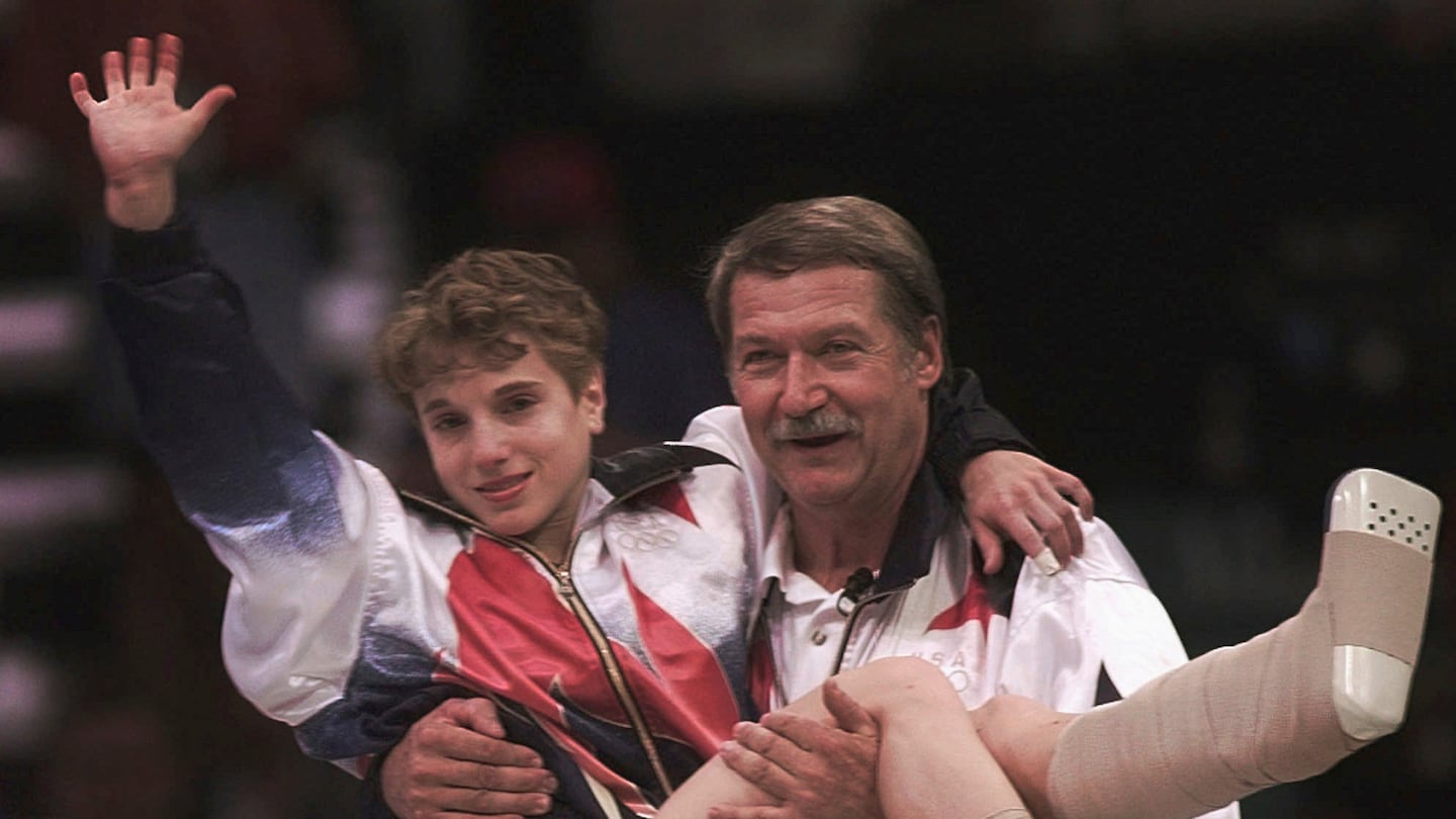 Former US women's gymnastics coach Bela Karolyi carried Kerri Strug to receive her gold medal for women's team gymnastics competition at the Centennial Summer Olympic Games in Atlanta on July 23, 1996. Karolyi died Friday at the age of 82.