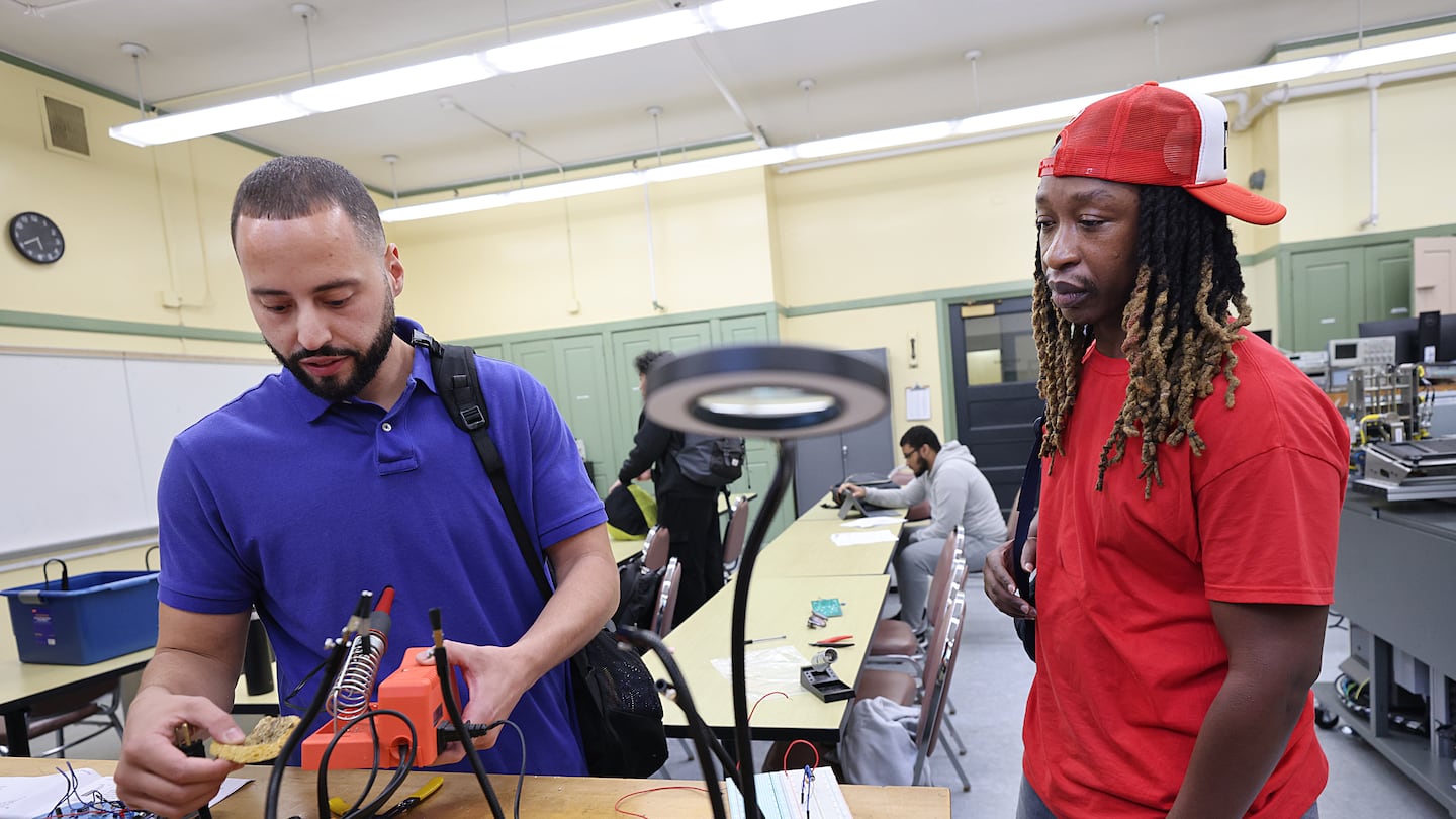 Osvaldo Medina (left) showed Alexander Harris a project in his Digital Principles lab class at the Benjamin Franklin Cummings Institute of Technology. Medina is studying engineering with a concentration in renewable energy technologies, while Harris is working toward a certificate in HVAC and refrigeration.