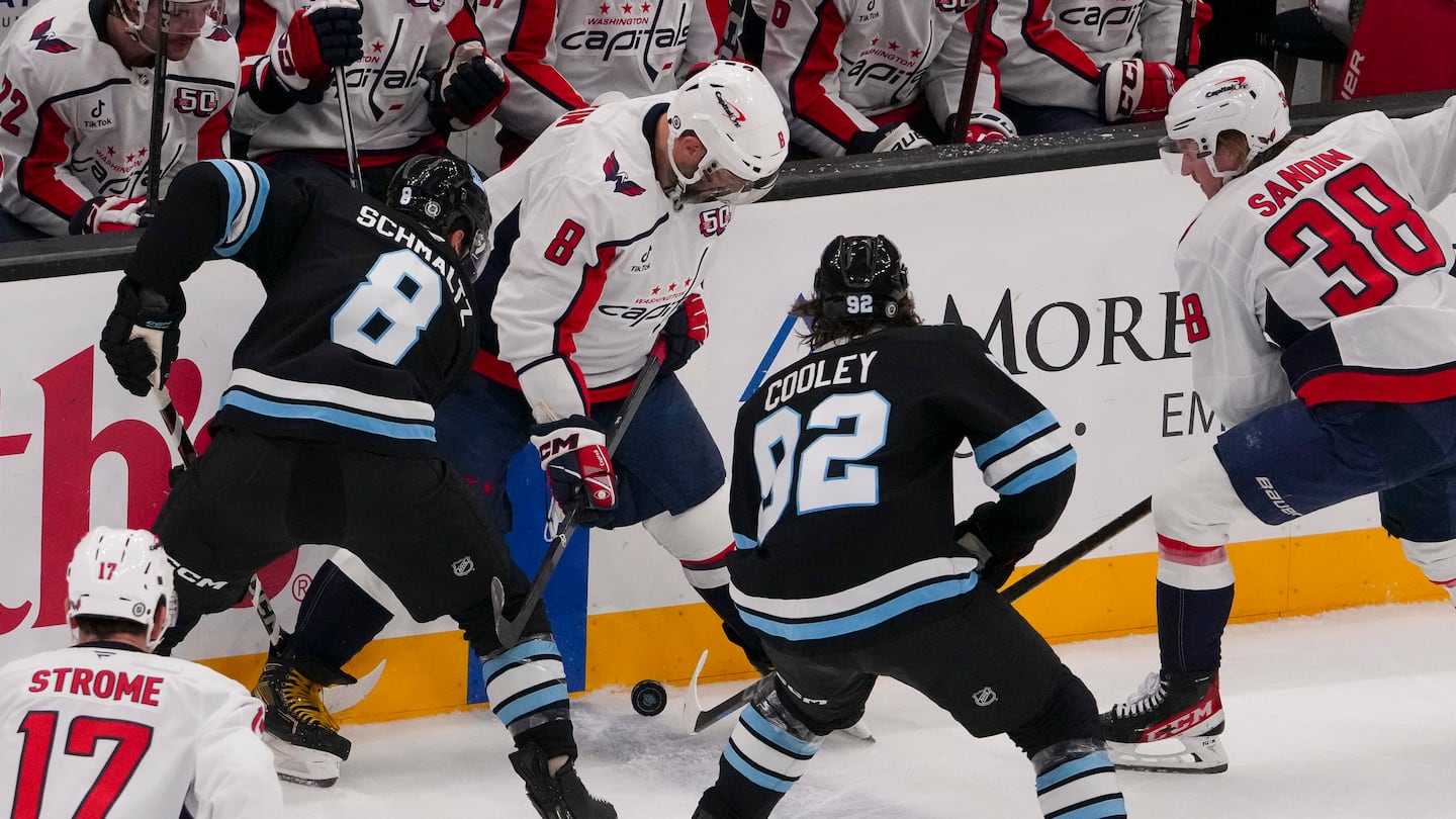 Capitals captain Alex Ovechkin (center), shown battling Utah's Nick Schmaltz (8) and Logan Cooley (92) in Monday night's game in Salt Lake City, was injured on shin-on-shin collision with Utah's Jack McBain 5:30 into the third period.