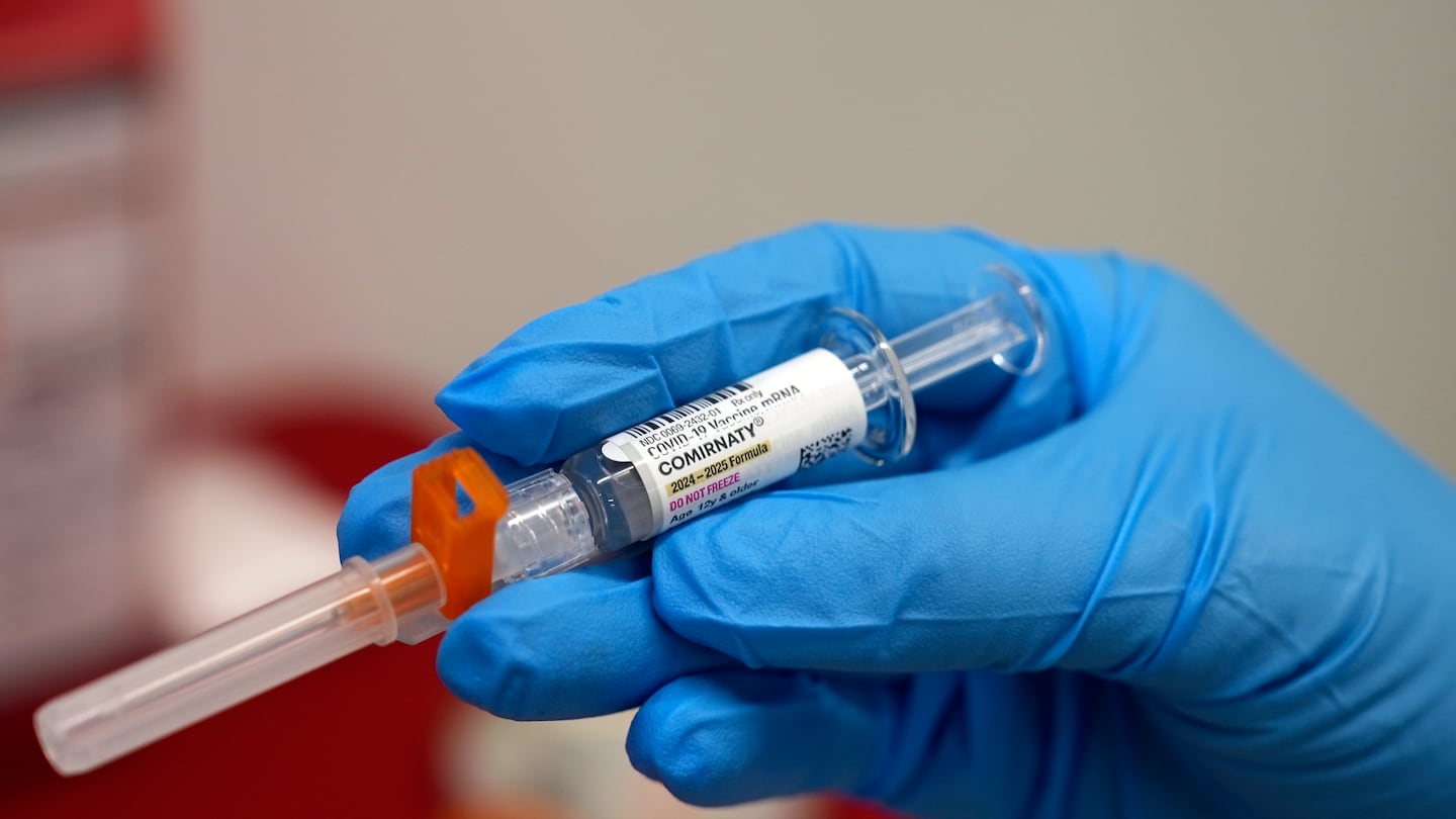 A pharmacist holds a COVID-19 vaccine at a pharmacy in New York in September.