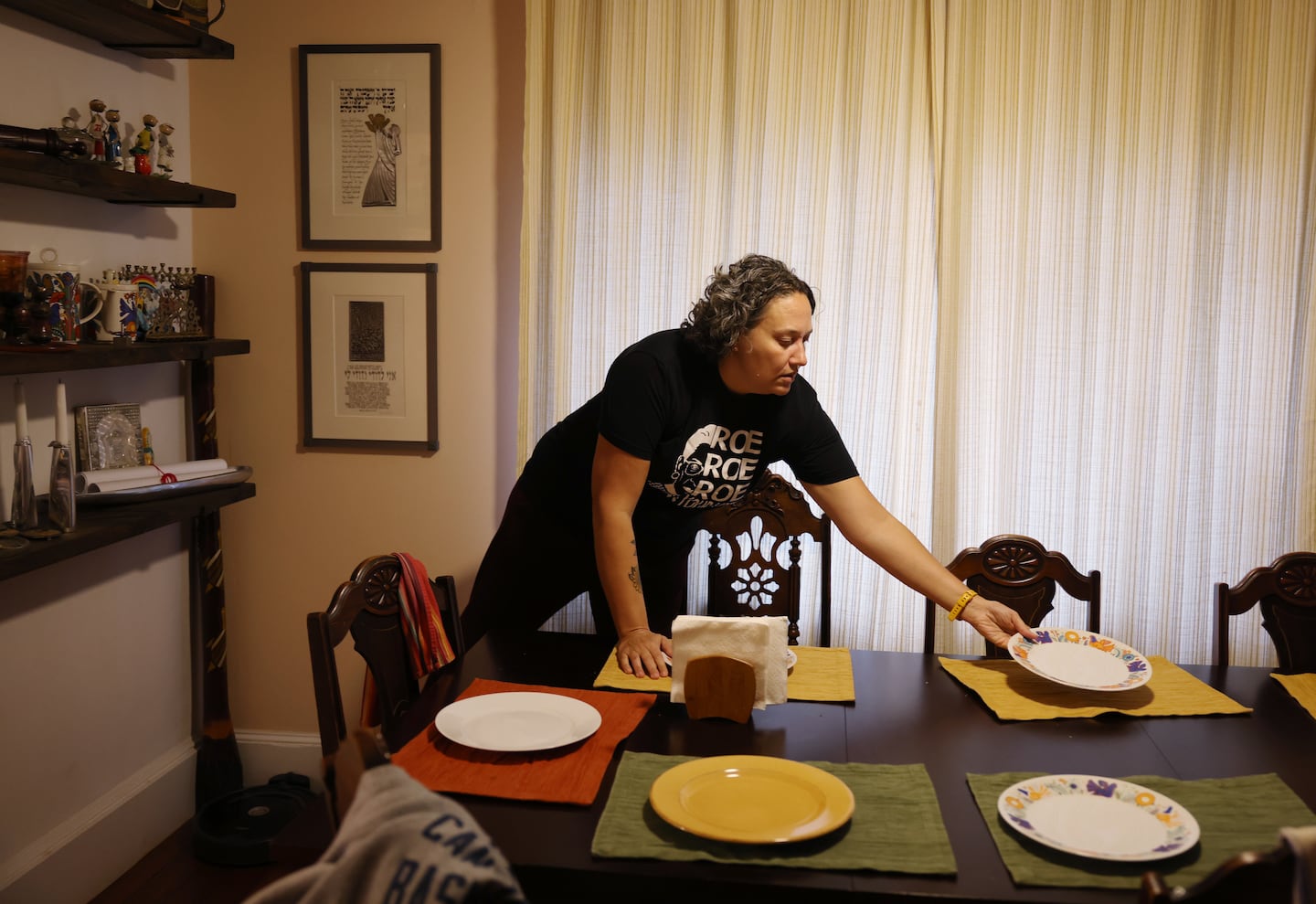 Leah Hart-Tennen sets the table for dinner at her family’s home. She and her husband, Eric Tennen, have provided a home to foster children for the past five years.