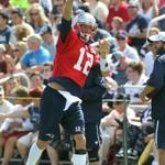 With his knee back in a brace, Tom Brady throws a pass during practice Thursday. (AP Photo/Stew Milne)