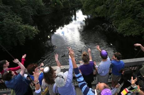 Members of the Shir Hadash congregation took part in a Tashlich service on Rosh Hashanah, symbolically casting away sins by throwing bread into moving water, at the pedestrian bridge over the Charles River at Albemarle Street in Newton. 
