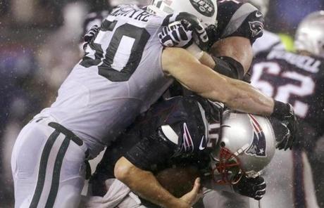 Jets linebacker Garrett McIntyre wrapped up Patriots quarterback Tom Brady in the third quarter.
