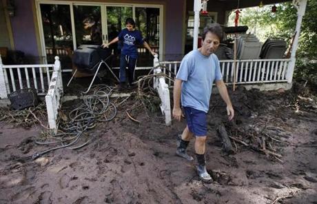 Allen Tawa, with his daughter Kayla, 17, walked out of his mud-caked near the southern edge of Boulder, Colo.
