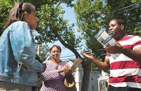 John Barros volunteers Maria Teixeira (middle) and Farid Dessources (right) talked with Carla Stovell in Dorchester.
