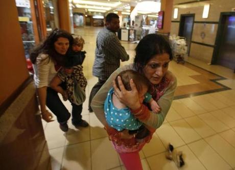 Women carrying children ran for safety as armed police hunted gunmen who attacked Westgate shopping center in Nairobi.
