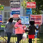 Campaign workers showed their support outside the Curley School in Jamaica Plain on Tuesday.