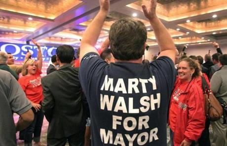 A man wearing a Martin Walsh t-shirt celebrated with other supporters.
