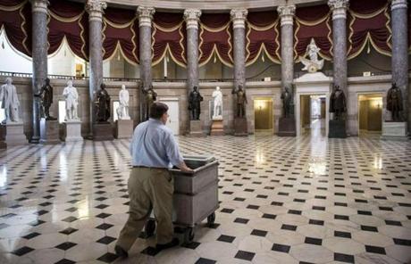 A wheeled a cart through Statuary Hall at the US Capitol.

