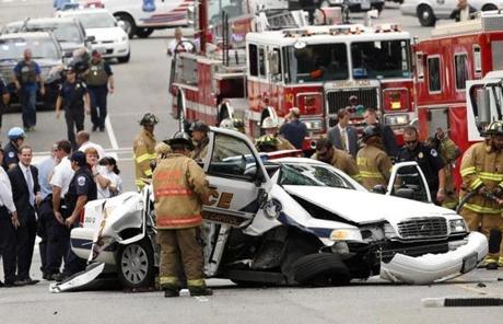 Rescue personnel stood around a smashed US Capitol Police car following the chase and shooting. 
