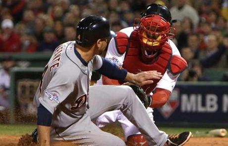Omar Infante was tagged out at home plate by Red Sox catcher David Ross.
