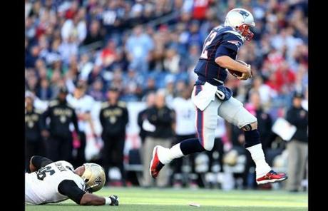 Tom Brady carried the ball as the Saints' Tom Johnson tried to defend.
