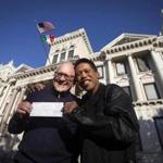 David Gibson (left) and Rich Kiamco displayed their wedding license receipt Friday in Jersey City after the state’s top court ruled same-sex marriages can begin Monday.