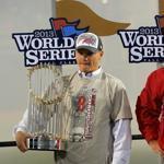 Red Sox manager John Farrell held up the World Series trophy, general manager Ben Cherington by his side. 